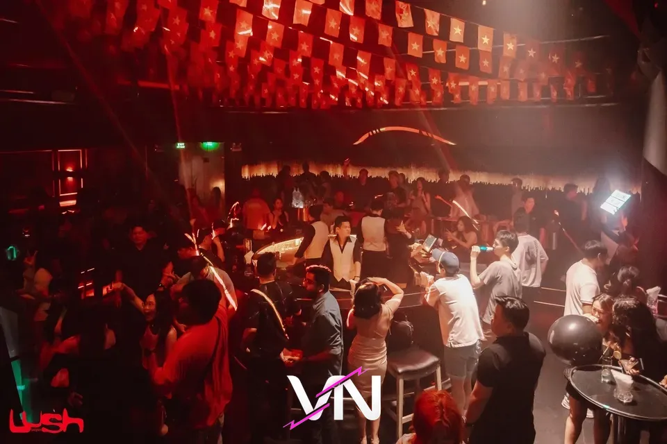 클럽 내부의 화려한 조명 아래 음악을 즐기는 사람들