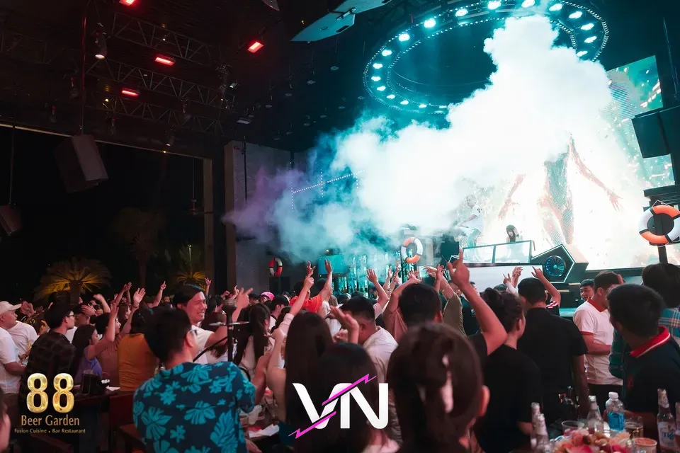 야외 무대에서 화려한 조명과 함께 DJ가 공연하는 모습